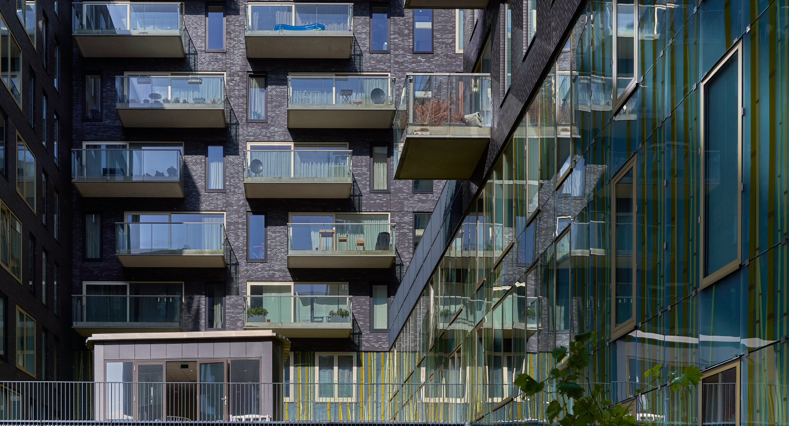 Fachada de un edificio residencial moderno con balcones acristalados